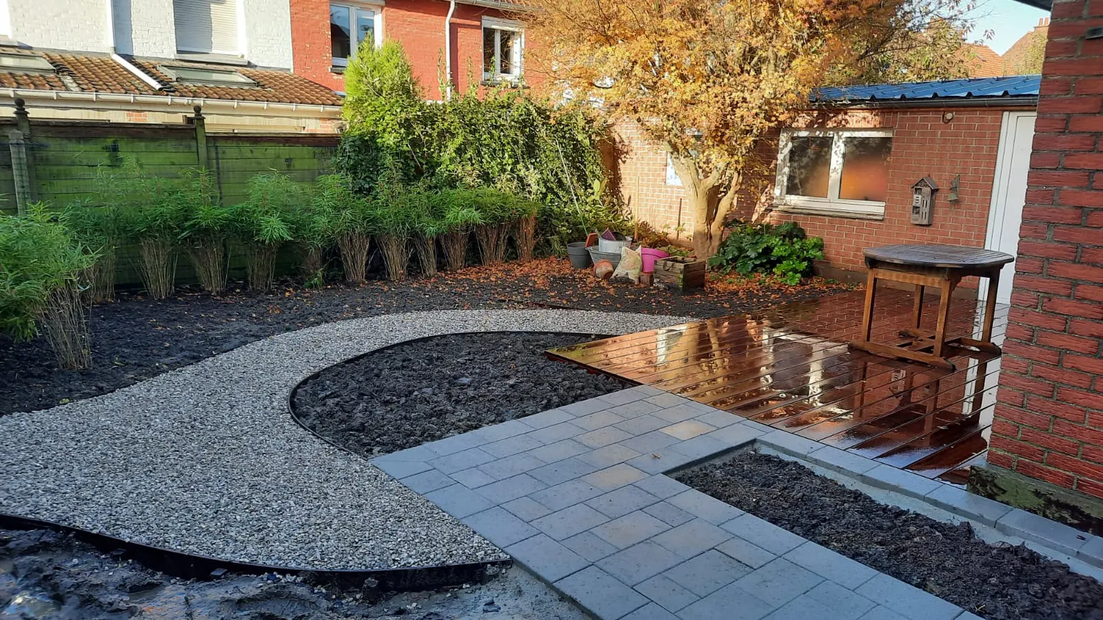 Aménagement paysager aux courbes minérales et terrasse en bois