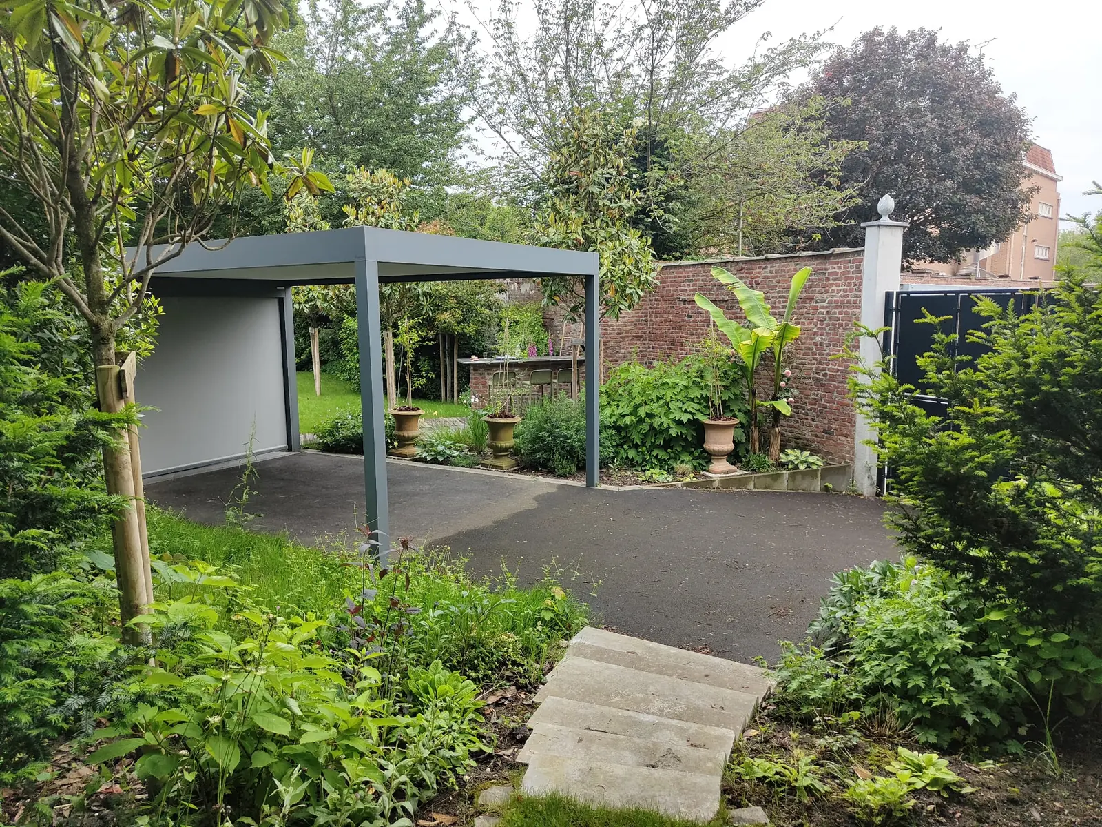 Pergola contemporaine intégrée dans un jardin arboré